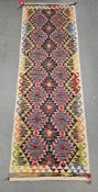 Chobi kilim blue ground runner, with two rows of seven lozenges and row of six, 242cm x 80cm