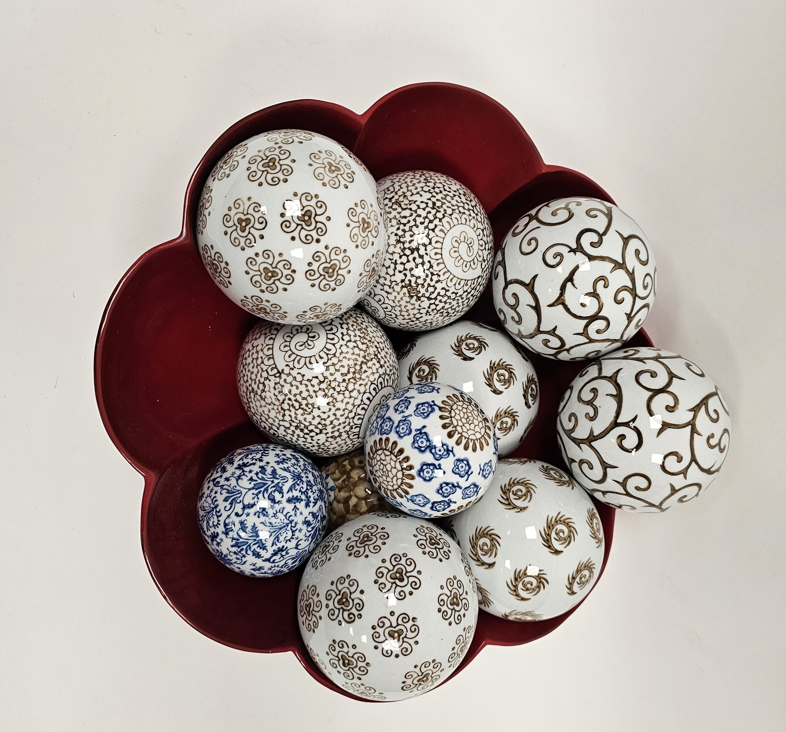 Quantity of printed ceramic spheres with scroll and stylised floral decoration in red lacquered bowl - Image 4 of 4