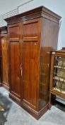 Large late Victorian mahogany two-door wardrobe containing a clothes rail and numerous coat hooks,