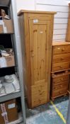 Modern pine storage cupboard having a large cupboard door opening to reveal various adjustable