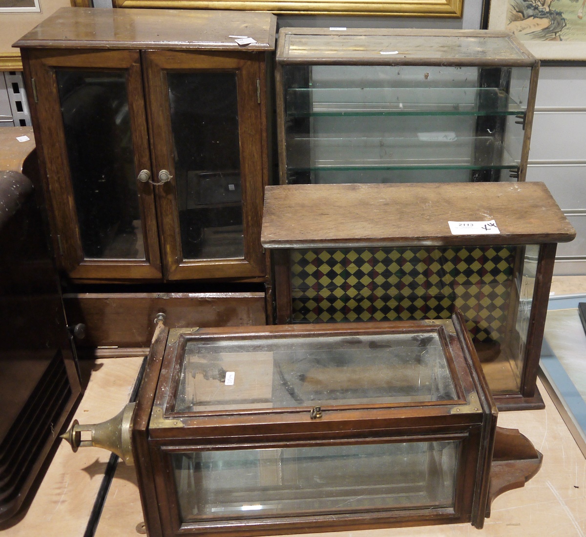 Wall cabinet with bevelled glass sides, fitted brass corners to the front opening drawer and a brass