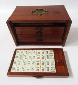 Bone and wood mahjong set with instruction booklet, in stained wood five-drawer table top cabinet