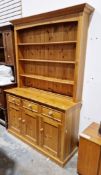 Modern pine dresser, the upper section with three plate shelves over a base with three drawers and