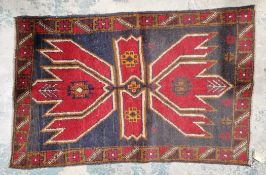 Afghan wool hand knotted rug, red with blue background of tribal design, 85cm x 132cm