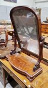 Victorian walnut framed swing mirror, the domed top plate supported on a pair of carved scrolling
