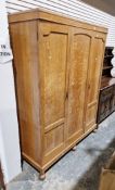 Early 20th century golden oak triple wardrobe in the 17th century manner, one panel door opening