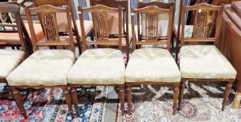 Set of four late Victorian walnut dining chairs with sunflower carved back rails and splats,