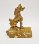 Chinese sancai ochre glazed terracotta roof tile surmounted by seated Pixiu, 26cm high