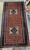 Eastern red ground rug with two central geometric medallions on geometric trelliswork field,