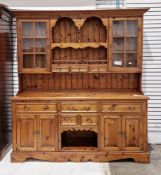 Modern pine dresser, the upper section with an arrangement of open plate shelves, three small