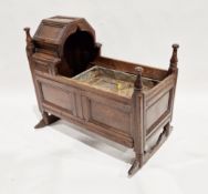 17th/18th century joined oak rocking cradle with hinged fold back hood, four turned finials and