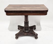 William IV rosewood fold-over card table with rounded corners, raised on a turned carved column