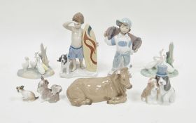Lladro figure of a boy surfer with his dog, 19cm high, boxed, Nao figure of a boy with skateboard,