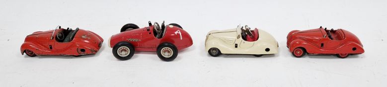 Three Schuco tinplate clockwork 'Examico 4001' cars, two red and one cream (two with keys)