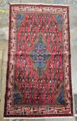 Hand knotted Iranian rug with symbols on red backgrounds, birds on blue in centre, colours in