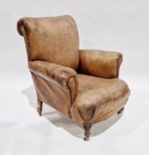Late 19th/early 20th century tan leather upholstered club armchair with brass studding and raised on