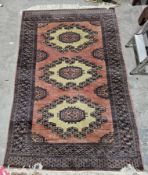 Pakistani pink/brown ground wool rug with three octagonal hooked medallions each enclosed by
