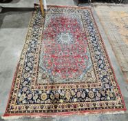 Iranian (Nasafabad) red ground wool carpet, with central floral medallion on woven floral field