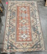 Eastern salmon ground rug with five floral lozenge medallions, zig-zag and geometric borders 194cm x
