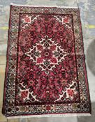 Iranian rug of fine quality 100% wool, red, blue, burgandy and green stylised field leading to a