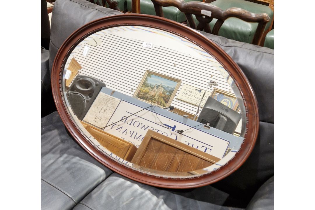 Early 20th century mahogany-framed oval mirror with a bevelled edge