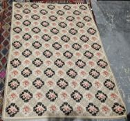 Hand stitched wool work tapestry with a pattern of rows of roses on alternating cream and black