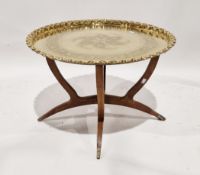 Middle Eastern folding table, the brass tray top with crimped edge and engraved floral detail,
