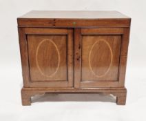 Early 19th century mahogany cupboard, the double panel doors with cross banded oval inlay, raised on