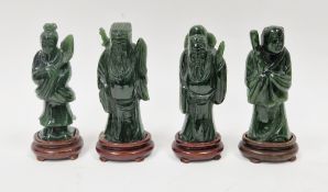 Set of four Chinese carved spinach jade immortals, each on integral wood stand, 12.5cm high (4)