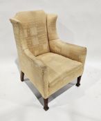 Early 20th century armchair raised on square oak supports and spade feet, upholstered in