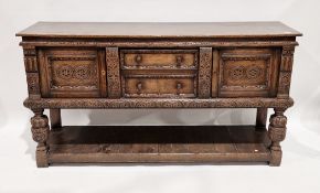 Reproduction oak dresser base in the Tudor manner by Titchmarsh and Goodwin, with carved foliate