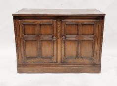 Ercol dark stained elm Old Colonial cabinet comprising two cupboard doors opening to a single shelf,