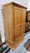 Modern pine double wardrobe, the two doors opening to a hanging space over a drawer below and plinth