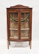 Early 20th century oak glazed bowfronted display cabinet with two green stained glass panels and