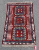 Eastern wool rug with three elephant's foot guls, in red, blue and grey, having geometric flowerhead