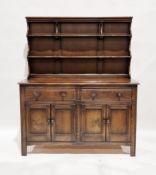 Ercol dark stained elm dresser, the back with two graduating plate shelves over a base of two