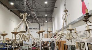 Two contemporary cream and gilt metal five-light chandeliers, each with scroll-shaped branches,