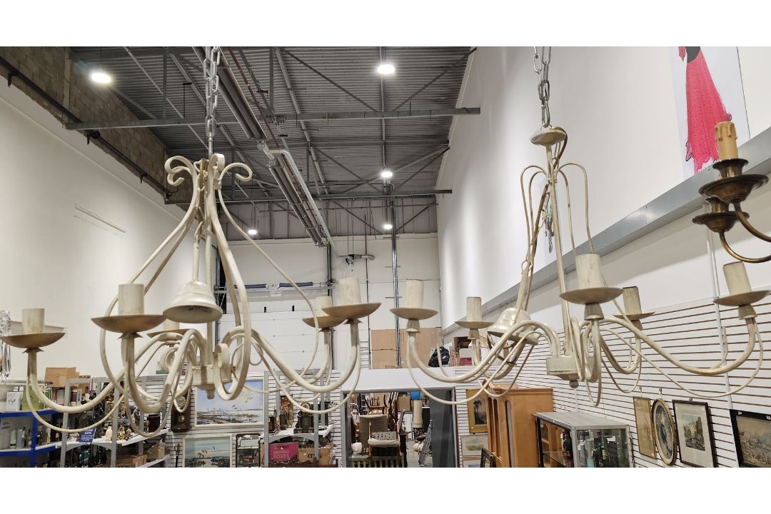 Two contemporary cream and gilt metal five-light chandeliers, each with scroll-shaped branches,