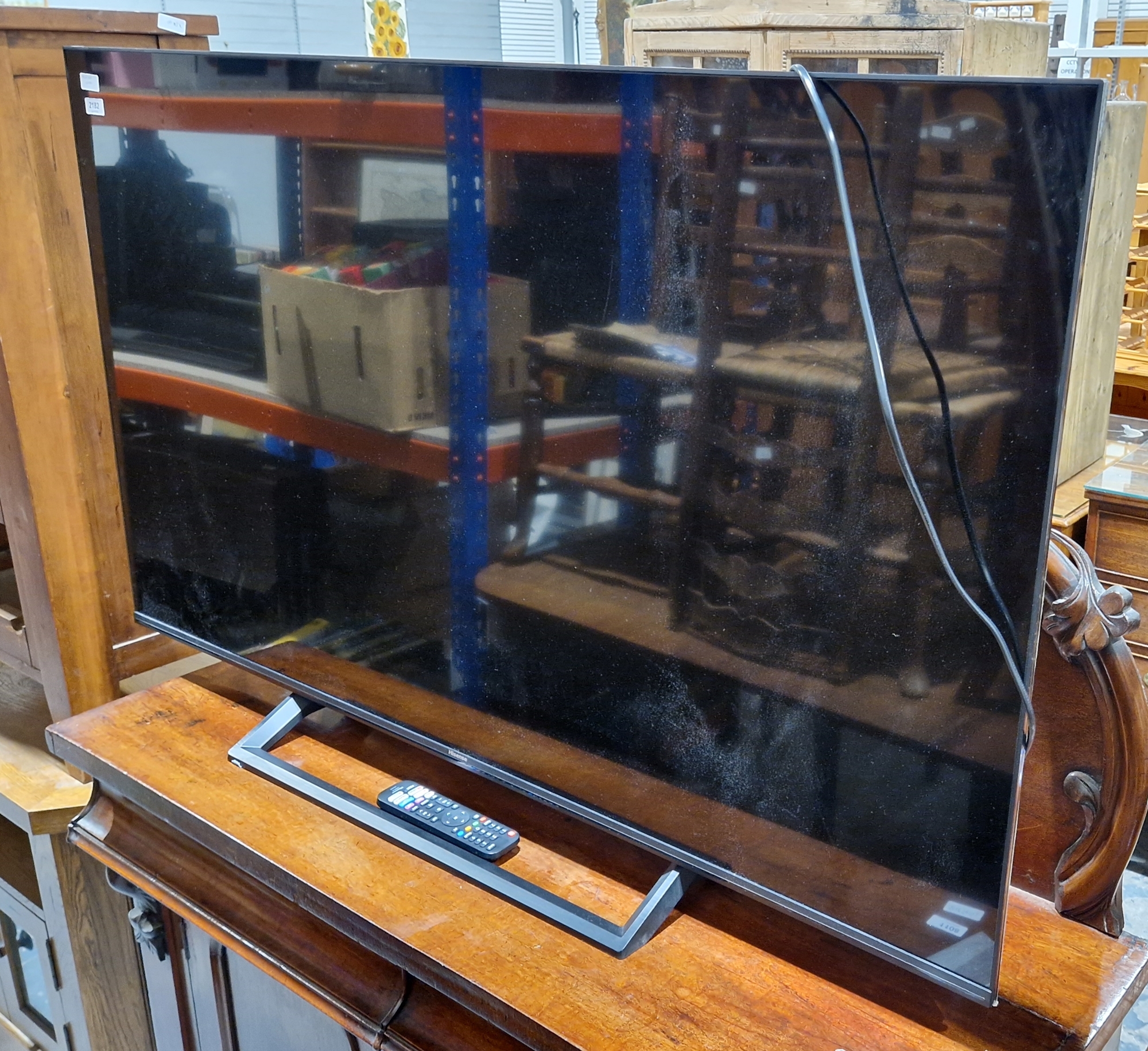 Hisense 55" flat screen television TV, table standing with remote control