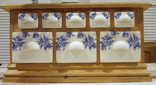 Herb and spice cabinet with ceramic drawers and wooden frame, the ceramic drawers decorated with