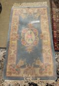 20th century Chinese machine made floor rug with floral sprays on a blue ground, 122cm x 64cm and