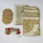 An Indian heavily embroidered cover in gold and silver thread with coloured silk details, gilt metal