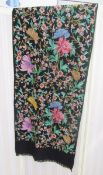 A black wool shawl with crewel work floral decorations in vivid colours, a turquoise silk shawl with