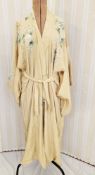 A pale mustard coloured silk kimono, early 20th century, printed with blossom in green, pinks and