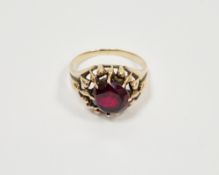 Synthetic ruby yellow metal ring, round mixed cut synthetic ruby claw set, tapered shoulders, ring