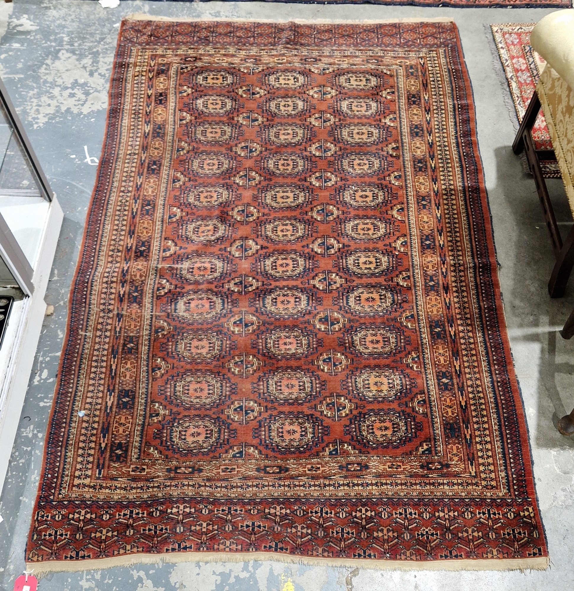 Bokhara-style Eastern wool rug, the red field with 11 rows of three octagonal guls and