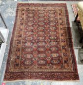 Bokhara-style Eastern wool rug, the red field with 11 rows of three octagonal guls and