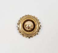 Gold-coloured metal target brooch with glass panel to reverse