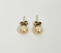 Pair of cultured pearl stud earrings, the pearls of approximately 8mm diameter, set on yellow