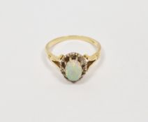 Gold-coloured metal, opal and white stone ring set oval opal surrounded by small white stones (